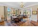 Elegant dining room boasts hardwood floors, chandelier, and views into the living area at 29 Indian Creek Rd, Locust Grove, GA 30248