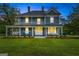 Charming two-story blue home featuring a large wrap-around porch and well-manicured lawn at 29 Indian Creek Rd, Locust Grove, GA 30248
