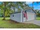 Detached blue garage with a white door and American flag, adding a touch of charm at 29 Indian Creek Rd, Locust Grove, GA 30248