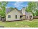 A serene backyard showcases a home's exterior, featuring a covered patio and a neatly manicured lawn at 35 Wenham Ln, Sharpsburg, GA 30277