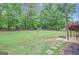 Expansive backyard with a stone fire pit, offering a private and tranquil outdoor space amid lush greenery at 35 Wenham Ln, Sharpsburg, GA 30277