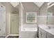 Bathroom featuring shower stall, jacuzzi tub, colored window and vanity at 35 Wenham Ln, Sharpsburg, GA 30277
