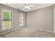 Carpeted bedroom with two large windows and a ceiling fan offers ample natural light at 35 Wenham Ln, Sharpsburg, GA 30277