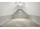 A carpeted bonus room under a pitched roof with a central window providing natural light at 35 Wenham Ln, Sharpsburg, GA 30277