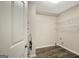 Neat laundry room with water heater and wooden floor plus wire shelving at 35 Wenham Ln, Sharpsburg, GA 30277