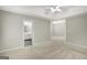 Main bedroom with neutral walls, carpet, ceiling fan, leading to bathroom at 35 Wenham Ln, Sharpsburg, GA 30277