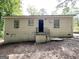 Exterior view of home featuring black front door, two windows, and concrete stairs at 830 Mercury Dr, Atlanta, GA 30331