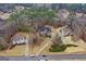 High-angle aerial view showing home's brick exterior, long driveway, surrounding lush green landscape and neighborhood at 1442 Swiftwater Cir, Mcdonough, GA 30252