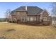 Exterior view of the beautiful brick home with a large backyard and wooden deck at 1442 Swiftwater Cir, Mcdonough, GA 30252