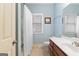Bright bathroom with white shower curtain, ceramic tile floor and wood vanity at 1442 Swiftwater Cir, Mcdonough, GA 30252