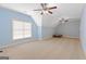 Large bedroom with blue walls, neutral carpet, and two ceiling fans for optimal comfort at 1442 Swiftwater Cir, Mcdonough, GA 30252