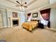 Spacious bedroom featuring a cozy fireplace, tray ceiling and beautiful decor at 1442 Swiftwater Cir, Mcdonough, GA 30252