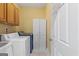 Functional laundry room with white cabinets, a sink, and modern washer and dryer units at 1442 Swiftwater Cir, Mcdonough, GA 30252