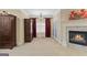 View of large main bedroom including decorative fireplace with red drapes, chandelier, and large armoire at 1442 Swiftwater Cir, Mcdonough, GA 30252