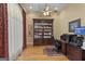A stately home office with beautiful wood floors, a coffered ceiling, and large wood bookcase at 1442 Swiftwater Cir, Mcdonough, GA 30252
