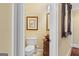Stylish powder room with decorative mirror, framed artwork, unique fixtures and wood accents at 1442 Swiftwater Cir, Mcdonough, GA 30252