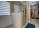 Bathroom featuring a glass shower with tan tile, paneled base, and a view into the walk-in closet at 1484 Stephens Pond Vw, Loganville, GA 30052