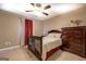 Bedroom featuring a bed, ceiling fan, dresser, red curtains, and neutral walls at 1484 Stephens Pond Vw, Loganville, GA 30052