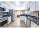 Open kitchen with stainless steel appliances and granite countertops adjacent to dining area at 1484 Stephens Pond Vw, Loganville, GA 30052