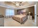 Spacious main bedroom featuring decorative tray ceiling and soft, natural light at 1484 Stephens Pond Vw, Loganville, GA 30052