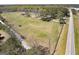 An aerial shot of the property with a barn, a large grassy field, and the home in the background at 1092 E Lake Rd, Mcdonough, GA 30252
