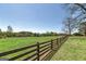 Spacious fenced-in backyard with lush green grass and mature trees, offering privacy and tranquility at 1092 E Lake Rd, Mcdonough, GA 30252