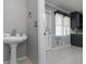 Powder room area leading to the kitchen features a pedestal sink and a window for natural light at 1092 E Lake Rd, Mcdonough, GA 30252