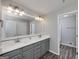 Bathroom with a dual sink vanity, updated lighting, framed mirror and modern color palette at 1092 E Lake Rd, Mcdonough, GA 30252