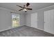 Bedroom featuring neutral gray walls, plush gray carpet, a window, and traditional ceiling fan at 1092 E Lake Rd, Mcdonough, GA 30252