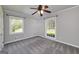 Bedroom with natural light from dual windows, gray carpet and trim, and traditional ceiling fan at 1092 E Lake Rd, Mcdonough, GA 30252