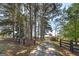 Scenic driveway flanked by mature trees and a fence, leading to a house nestled in the landscape at 1092 E Lake Rd, Mcdonough, GA 30252