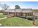 Spacious brick ranch with accessible ramp, complemented by lush green lawn and mature landscaping at 1092 E Lake Rd, Mcdonough, GA 30252