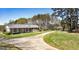 Lovely brick home with a long driveway and well-maintained lawn, set amidst mature trees at 1092 E Lake Rd, Mcdonough, GA 30252