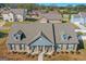 Aerial view of a charming single-story home featuring a brick facade, dormer windows, and manicured landscaping at 1141 Abundance Dr, Locust Grove, GA 30248