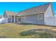 Exterior view of the backyard with well-maintained lawn, privacy fence, and covered patio at 1141 Abundance Dr, Locust Grove, GA 30248