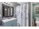 Well-lit bathroom with a blue vanity, decorative shower curtain, and modern fixtures at 1917 Lake Ridge Ct, Jonesboro, GA 30236