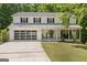 Charming two-story home with a welcoming front porch and modern garage door, nestled among lush greenery at 1917 Lake Ridge Ct, Jonesboro, GA 30236