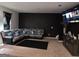 Modern living room with gray sectional sofa, patterned accent wall, and a large screen TV at 99 Cooperton, Villa Rica, GA 30180