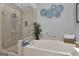 Inviting bathroom featuring a soaking tub, a glass-enclosed shower, and a plant for a spa-like ambiance at 120 Masters N Dr, Peachtree City, GA 30269