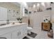 Cozy bathroom with cream colored vanity, patterned wallpaper, and decorative shelving at 120 Masters N Dr, Peachtree City, GA 30269
