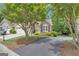Charming home featuring a manicured front yard, mature trees, and a welcoming driveway at 120 Masters N Dr, Peachtree City, GA 30269