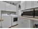 Functional laundry room featuring modern appliances, ample cabinet space, and a microwave for added convenience at 120 Masters N Dr, Peachtree City, GA 30269