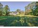 Wide backyard view showing well-kept grass, secure fencing, and mature trees offering shade at 100 Clydesdale Ct, Tyrone, GA 30290