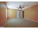 Bedroom with tan carpet, ceiling fan, and orange walls at 100 Clydesdale Ct, Tyrone, GA 30290