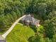 Aerial view of brick home featuring a long driveway and lush lawn and surrounded by mature trees at 127 Darwish Dr, Mcdonough, GA 30252