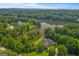 Breathtaking aerial view of a luxury lakeside home nestled among lush trees at 127 Darwish Dr, Mcdonough, GA 30252
