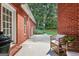 Brick back porch with seating offers a peaceful view of the landscaped backyard at 127 Darwish Dr, Mcdonough, GA 30252