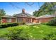 Spacious backyard with lush lawn, mature trees and an expansive brick home at 127 Darwish Dr, Mcdonough, GA 30252