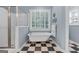 Elegant bathroom featuring a standalone tub, glass shower, and checkered tile floor at 127 Darwish Dr, Mcdonough, GA 30252