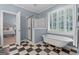 Stylish bathroom with standalone tub, shower, checkered floor, and access to the bedroom at 127 Darwish Dr, Mcdonough, GA 30252